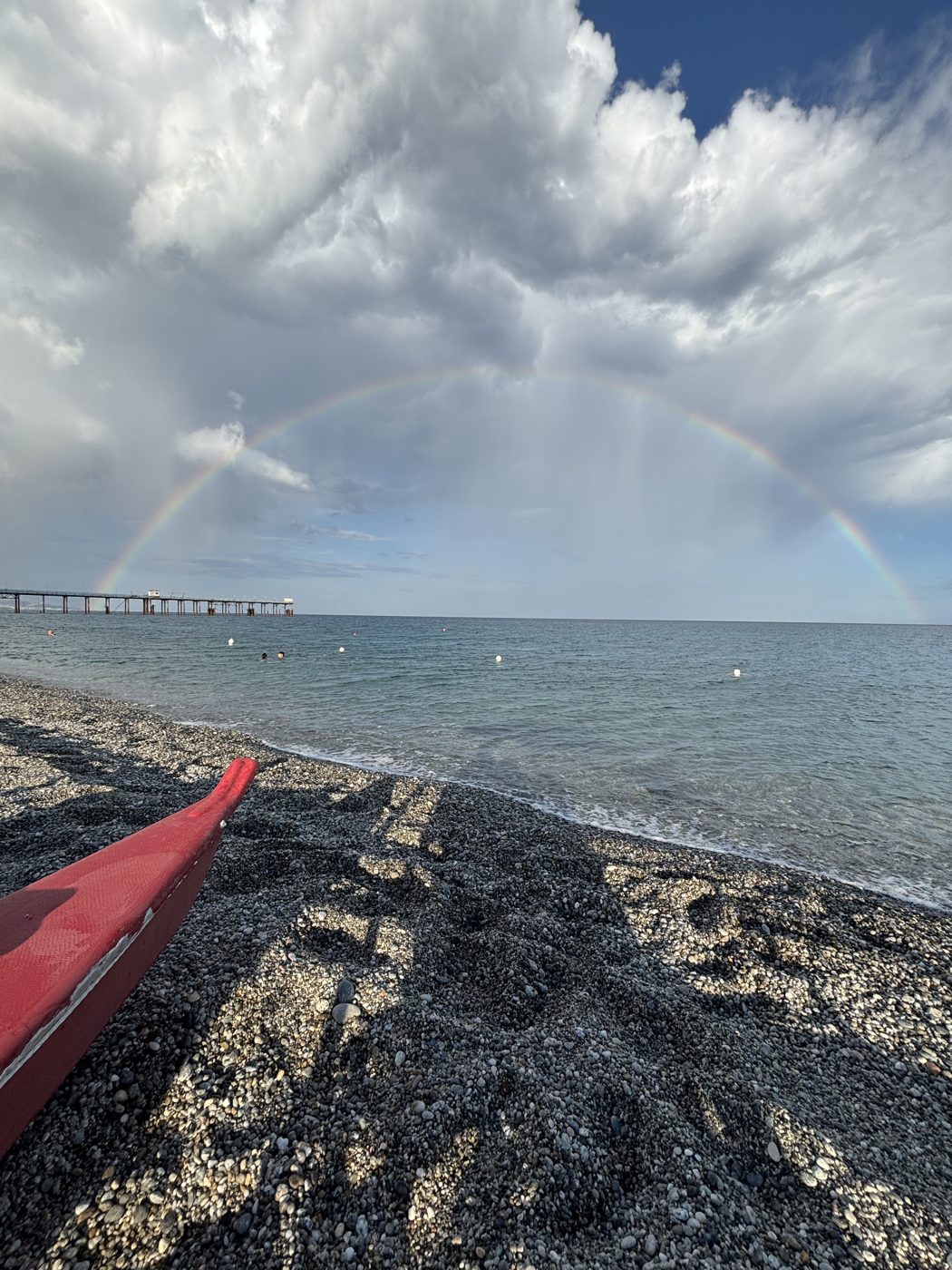 Mare con arcobaleno e canoa