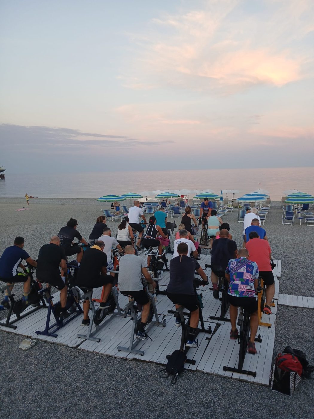 Lezione di spinning in spiaggia al tramonto